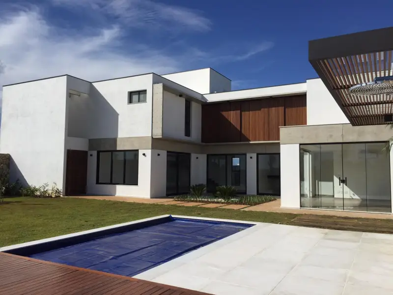 Casa entregue pela Contractor no Alpha Ville, Sorocaba: fachada branca com brise de madeira e piscina