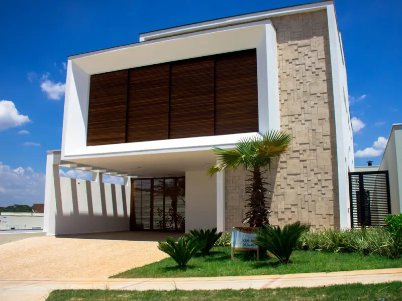 Residência entregue pela Contractor no Condomínio Giverny, Sorocaba: fachada com pedra e brise de madeira